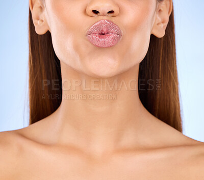 Buy stock photo Beauty, skincare and lips kiss with a model pout with lip gloss makeup in studio. Cosmetic, mouth and healthy natural glow of a woman with clear and smooth texture skin with isolated blue background