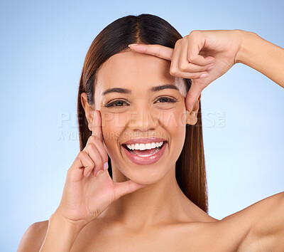 Buy stock photo Woman, beauty and hands on face portrait for skincare dermatology cosmetics in studio. Model smile on blue background with frame for self care, facial glow and healthy or clean skin with results