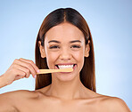 Portrait, toothbrush and smile with a model woman in studio on a blue background for oral hygiene. Mouth, cleaning and dental with an attractive young female brushing her teeth for whitening
