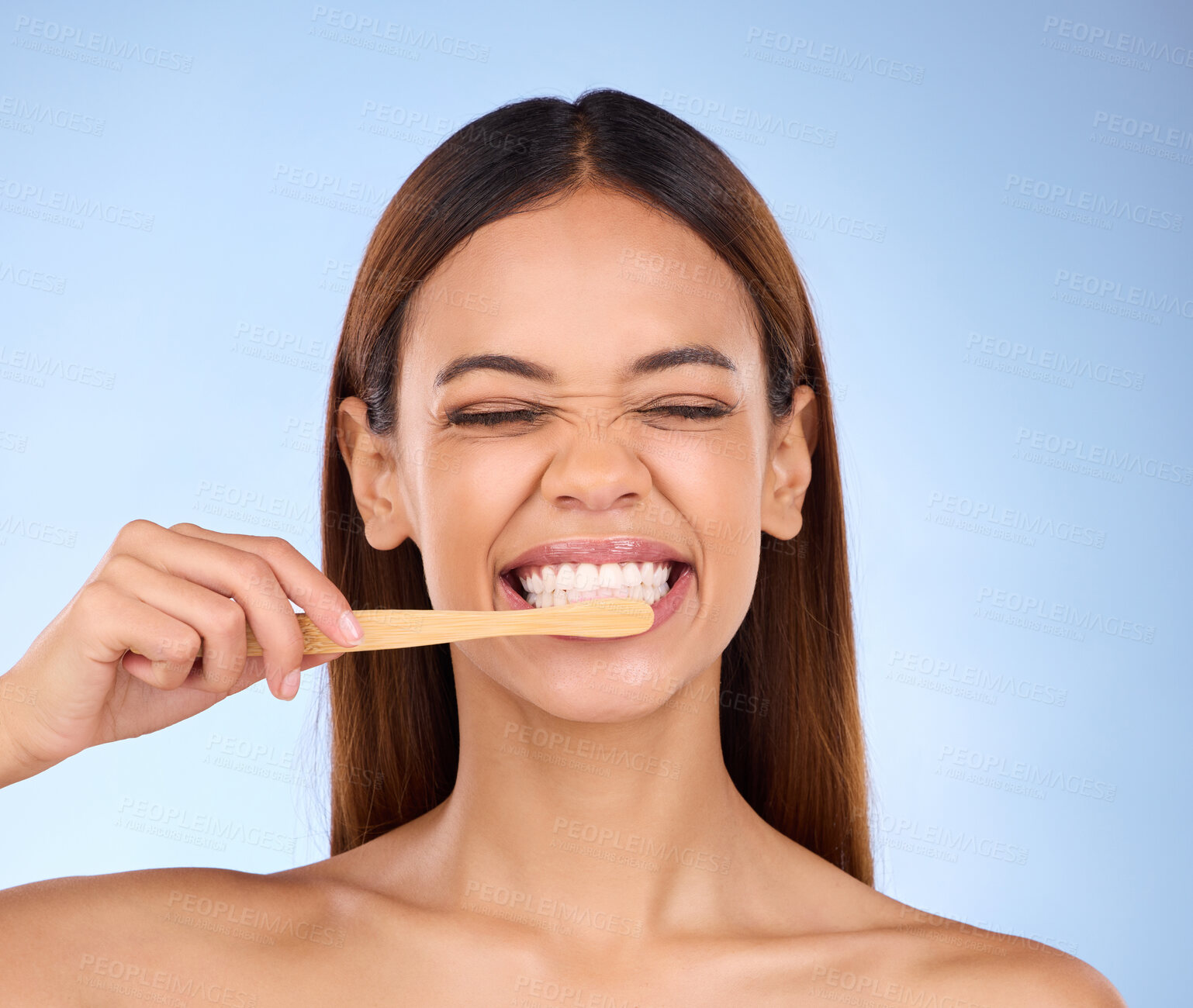 Buy stock photo Toothbrush, toothpaste and cleaning with a woman in studio on a blue background for oral hygiene. Mouth, dentist and dental with an attractive young female brushing her teeth for healthy gums