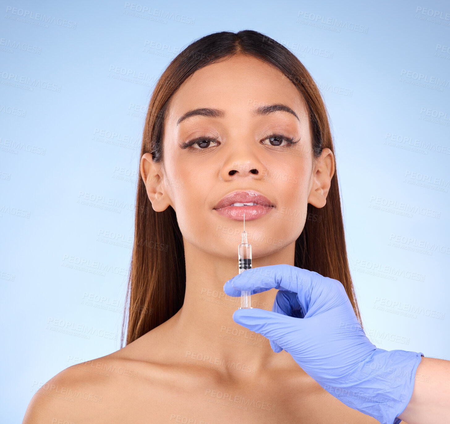 Buy stock photo Portrait, lips and injection of woman on studio, blue background and facial beauty. Young female model, lip filler and needle for plastic surgery, skincare transformation and aesthetic face change 