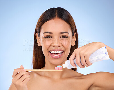 Buy stock photo Portrait, toothbrush and dental with a model woman in studio on a blue background for oral hygiene. Mouth, cleaning and smile with an attractive young female brushing her teeth for whitening