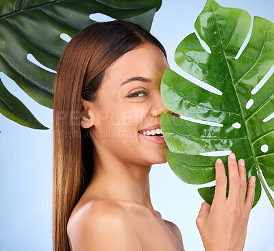 Buy stock photo Woman, portrait and leaf in natural beauty and organic skincare cosmetics for self love or care on blue studio background. Happy female with smile holding eco green plant for sustainable wellness