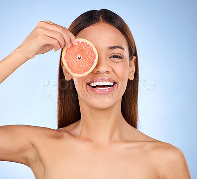 Buy stock photo Beauty, woman and grapefruit for face portrait with a smile for skincare dermatology. Model on a blue background for self care, facial glow and healthy fruit with vitamin c for clean skin in studio