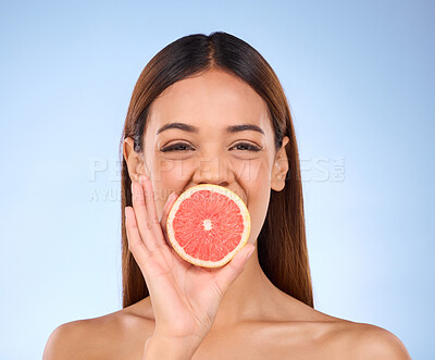 Buy stock photo Grapefruit, woman and beauty face portrait for skincare dermatology and vitamin c. Female model on a blue background for self care, facial glow and healthy fruit for natural and clean skin in studio