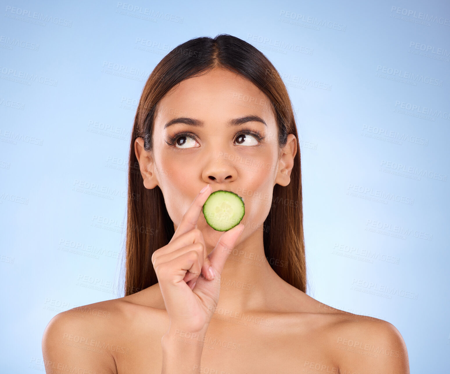 Buy stock photo Cucumber, woman and skincare face portrait with beauty and dermatology cosmetics. Female model on a blue background thinking about self care, facial glow and healthy fruit for natural skin in studio