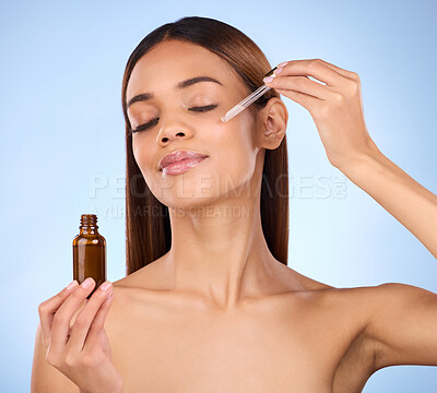 Buy stock photo Beauty, skincare and cosmetics, hispanic woman with serum in pipette for anti aging skin glow on blue background. Makeup, facial repair and face of model with solution or collagen product in studio.