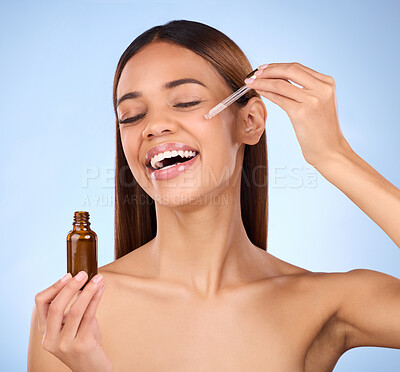 Buy stock photo Beauty, skincare and hispanic woman with smile and serum in pipette for anti aging skin glow on blue background. Cosmetics, facial repair and face of model with solution or collagen product in studio