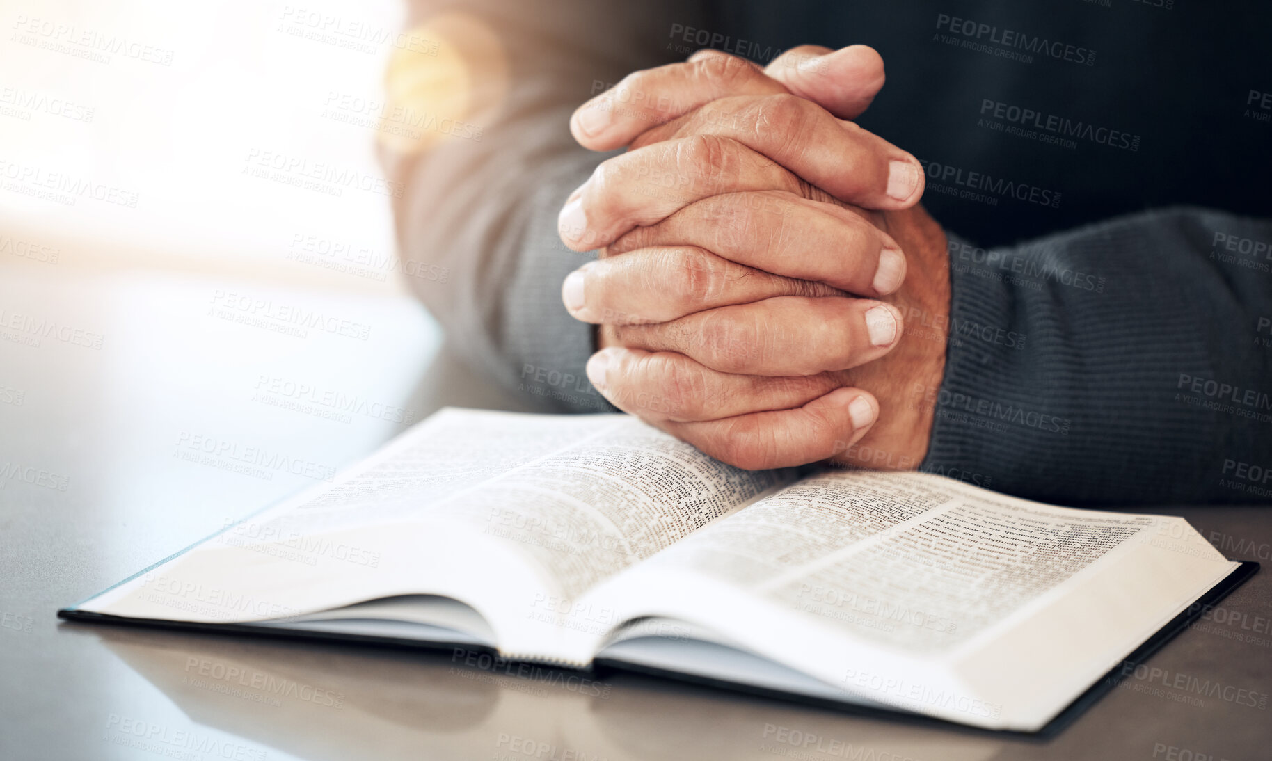 Buy stock photo Bible, hands and prayer of a man reading christian text for spiritual healing and religion. Lens flare, hand closeup and praying of a person with peace and a book for praise, support and hope