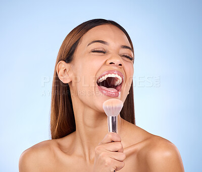 Buy stock photo Skincare, beauty and woman with brush, makeup and happiness against blue studio background. Female, lady and cosmetics tool with laugh, foundation and natural skin glow with joy, cheerful and facial