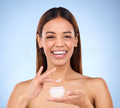 Buy stock photo Woman, portrait and face with moisturizer creme for beauty skincare cosmetics, self love or care against a blue studio background. Happy female with lotion or moisturizing cream for soft perfect skin