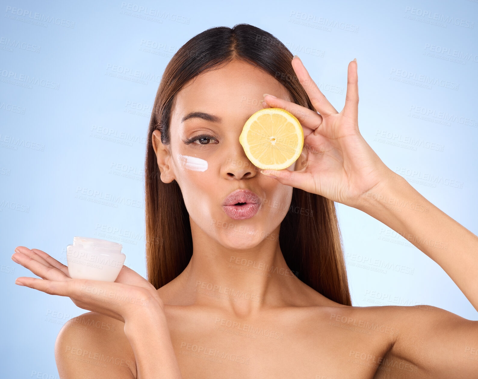 Buy stock photo Woman, moisturizer cream and lemon for natural skincare, beauty and vitamin C against blue studio background. Portrait of female holding citrus fruit, creme or lotion for healthy organic nutrition