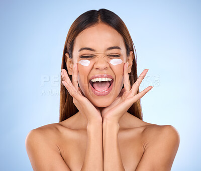 Buy stock photo Dermatology, portrait of excited woman with cream on face and anti aging skin care on blue background. Cosmetics, facial and happy hispanic model, moisturizer solution or collagen product in studio.