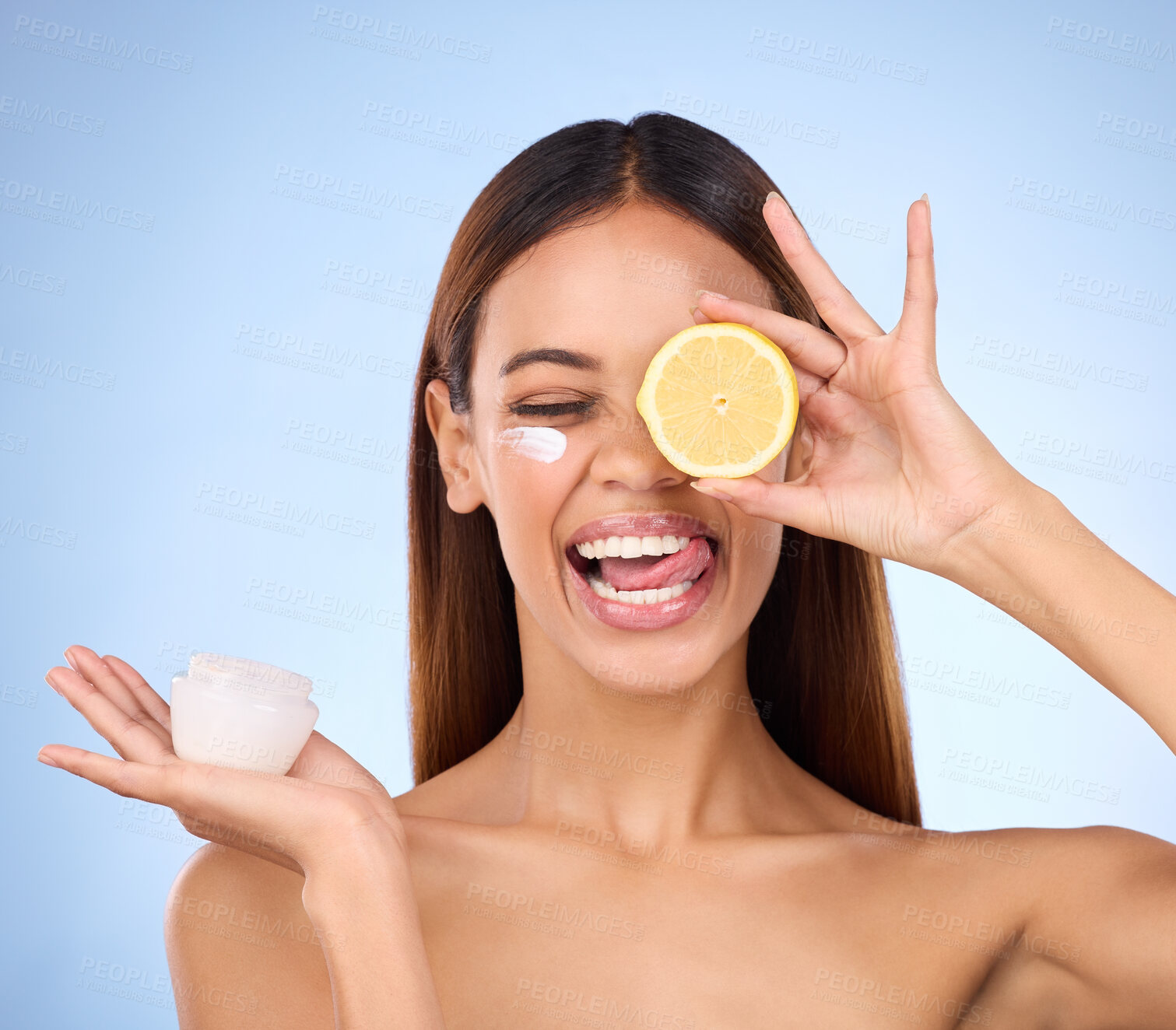 Buy stock photo Woman, moisturizer cream and lemon for natural skincare, beauty and vitamin C against a blue studio background. Female holding citrus fruit, creme or lotion for healthy organic nutrition or facial