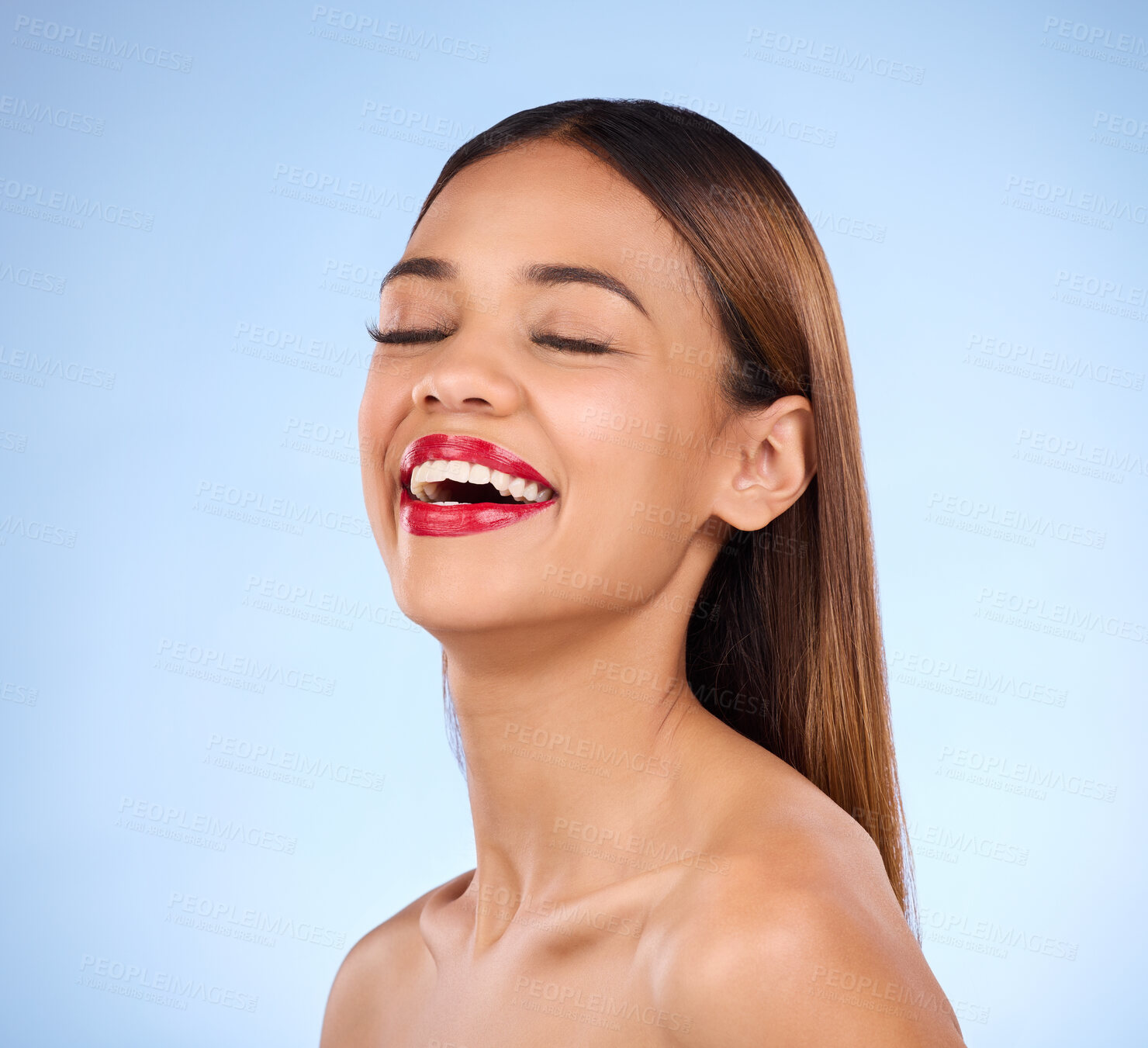 Buy stock photo Beauty, woman and red lipstick makeup while laughing with cosmetics on face in studio. Happy aesthetic female model person on a blue background for self care, facial glow and shine or color for skin