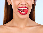 Beauty, health and raspberry with mouth of woman in studio for nutrition, diet and detox. Organic food, natural and self care with girl model eating fruit on blue background for wellness and glow