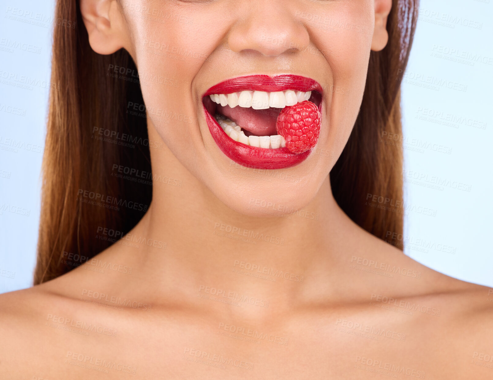 Buy stock photo Beauty, health and raspberry with mouth of woman in studio for nutrition, diet or detox. Cosmetics, natural and self care with girl model eating fruit on blue background for wellness, organic or glow