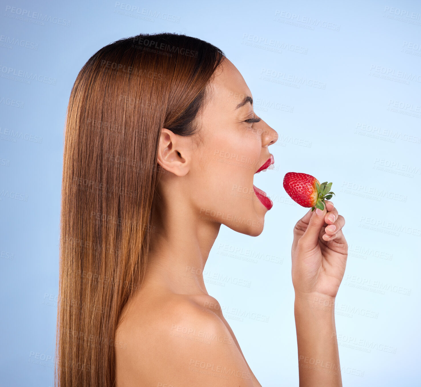 Buy stock photo Beauty, wellness and profile of woman with strawberry on blue background for diet, nutrition and healthy eating. Skincare, happy and girl with fruit in studio for cosmetics, makeup and natural snack