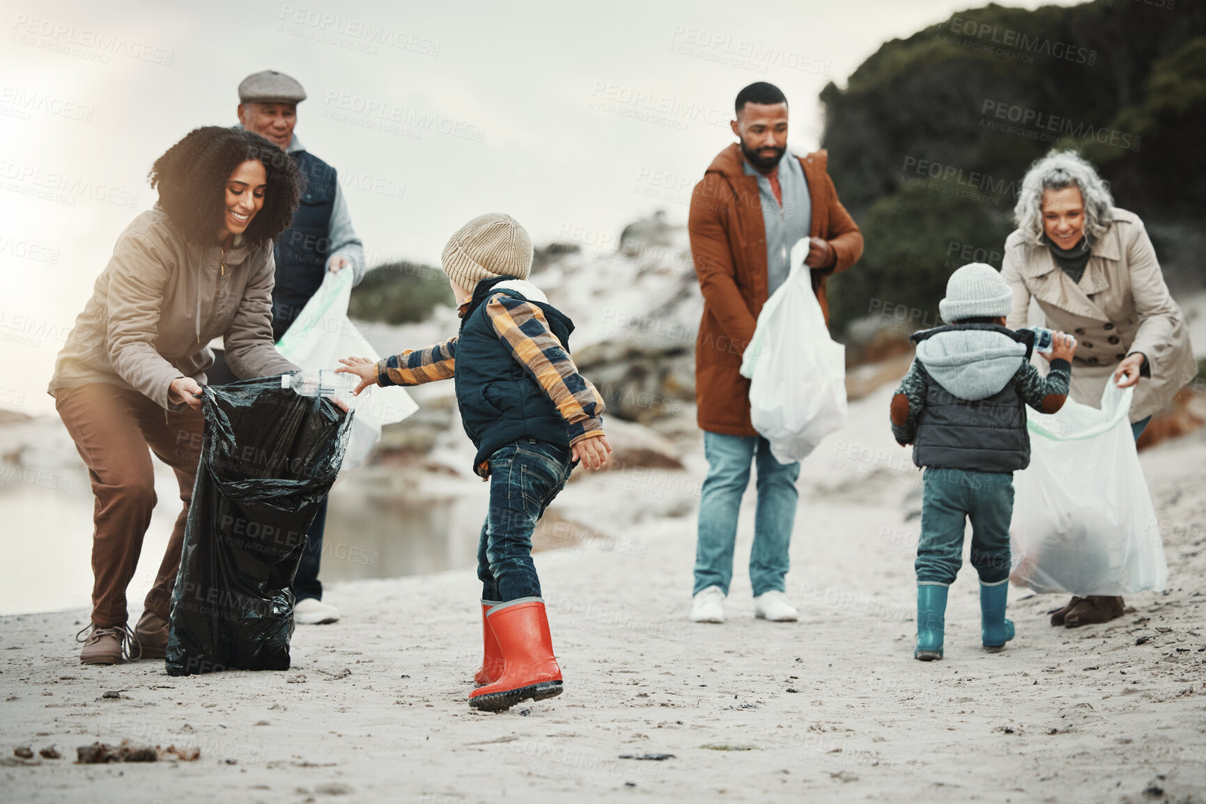 Buy stock photo Garbage, beach cleaning and children, family or volunteering group in education, learning and community service. Grandparents, people and kids helping with plastic waste for pollution on earth day