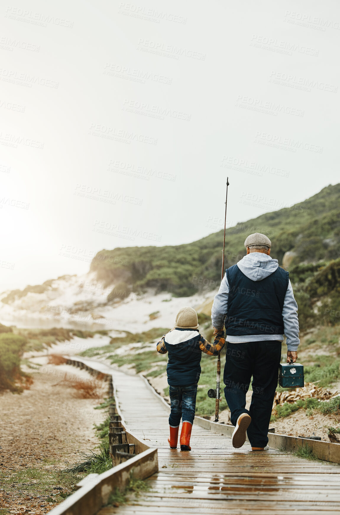 Buy stock photo Walking, fishing and grandfather with child outdoor for lesson, leisure activity or hobby. Travel, bonding and back of senior man with kid to teach him to catch fish while on vacation or weekend trip