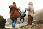 Nature fitness, holding hands and hiking family of mother, father and child walking, play and bond on mountain adventure. Love, freedom peace or back view of winter people trekking on outdoor journey