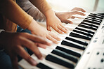 Hands, parent and child playing piano as development of skills together and bonding while making music in a home. Closeup, musical and kid learning a song on an instrument and father teaching