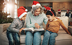 Christmas, photo album or children with a senior woman and kids looking at photographs during festive season. Family, love or celebration with a grandmother and grandchildren holding a picture book