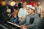 Boy, music keyboard and christmas in family home with smile, playing and creative skill with grandmother. Male kid, young musician and grandparents by piano for holiday cheer, bond and pride in house