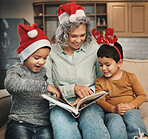 Christmas, photo album or children with a happy grandmother and kids looking at photographs during festive season. Family, love or celebration with a woman and grandchildren holding a picture book