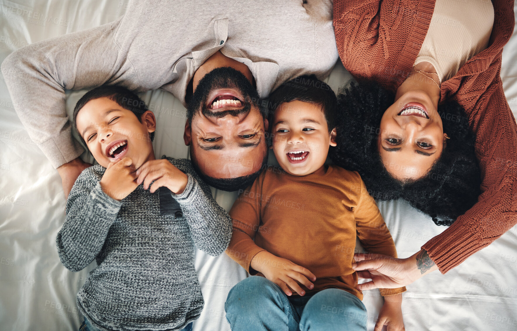 Buy stock photo Laughing, family and top view portrait on bed in bedroom, bonding and care in home. Love, smile and happy mother, comic father and funny children playing, having fun and enjoying joke time together.