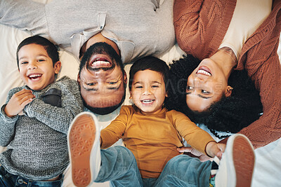 Buy stock photo Happy, above and portrait of a family on a bed for relaxation, bonding and quality time. Laughing, smile and carefree parents with children in the bedroom to relax and play in the morning together 