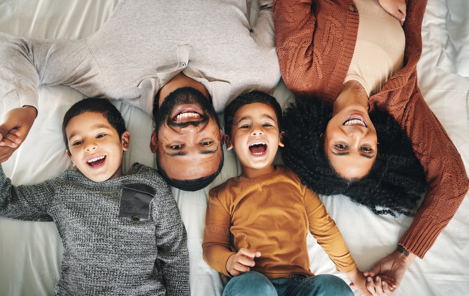 Buy stock photo Laughing, family and top view portrait on bed in bedroom, bonding and care in home. Love, smile and happy mother, comic father and funny children playing, having fun and enjoying joke time together.