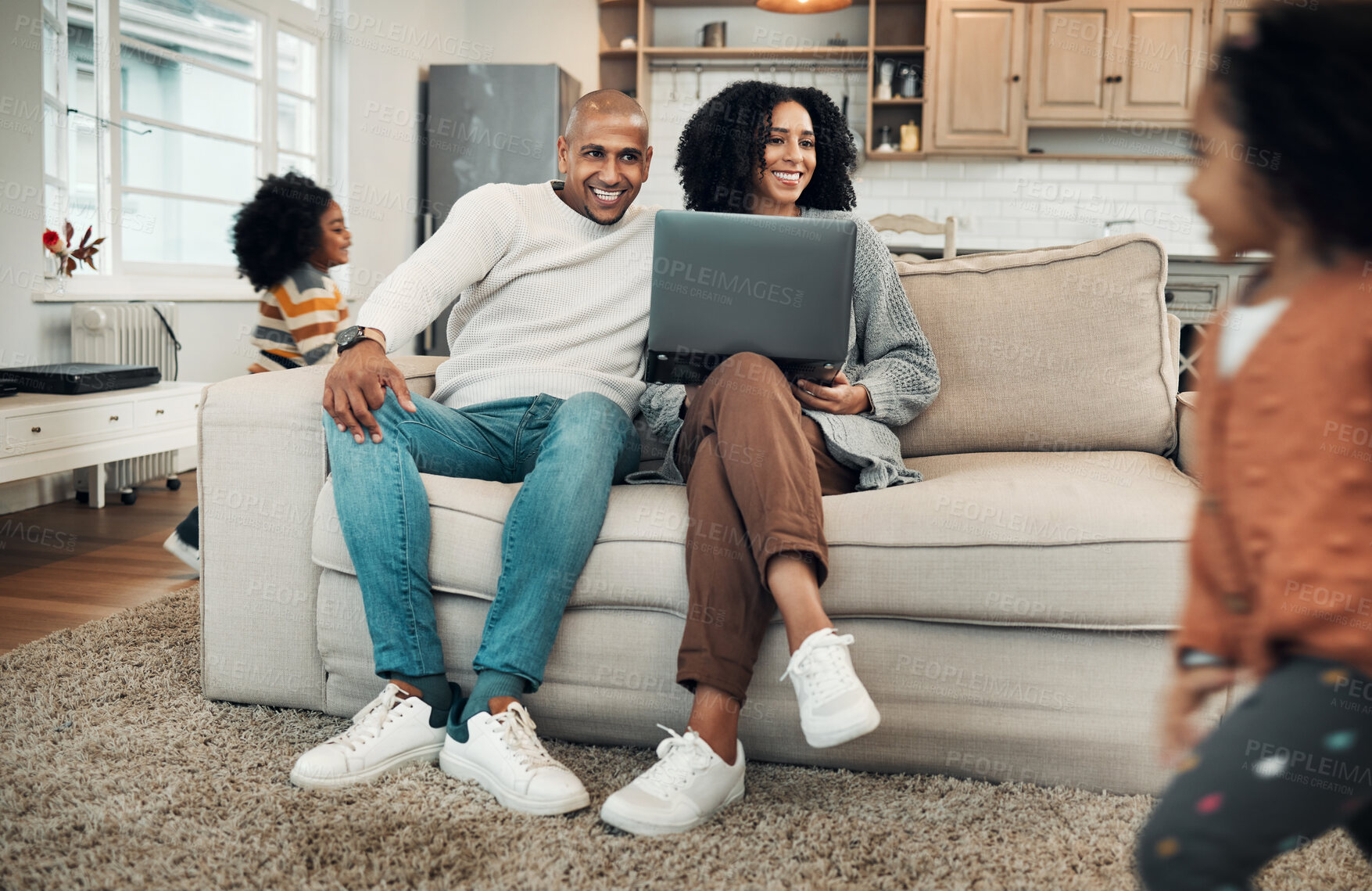 Buy stock photo Parents, family and kids playing in a home or house with mom and dad working on laptop and spending quality time together. Happy, playful and young couple or mother and father watching children play