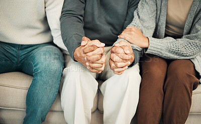 Buy stock photo Trust, love and family holding hands on sofa for comforting embrace, prayer and support together at home. Solidarity, empathy and connected parents and adult children for care, compassion and praying