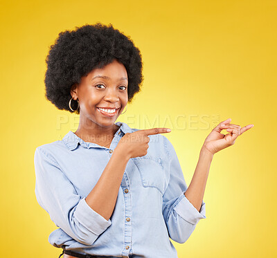 Buy stock photo Happy, portrait of a black woman in studio pointing at mockup space for advertising or marketing. Happiness, smile and African female model showing mock up for product placement by yellow background.