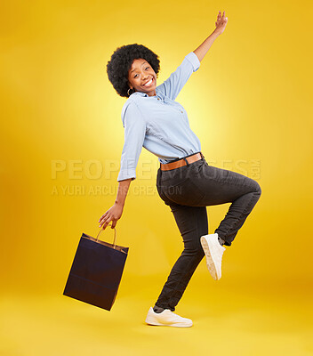 Buy stock photo Bag, portrait and happy black woman shopping, excited and celebrating sale in studio on yellow background. Face, shopper and girl customer cheerful after boutique, retail or store discount isolated