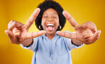 Happy, excited and black woman with a peace sign in studio with positive and goofy mindset. Happiness, smile and African female model with an afro posing with chill hand gesture by yellow background.