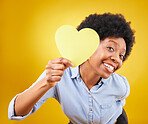 Portrait, heart and social media with a black woman in studio on a yellow background for love or affection. Emoji, shape and romance with an attractive young female feeling excited for valentines day