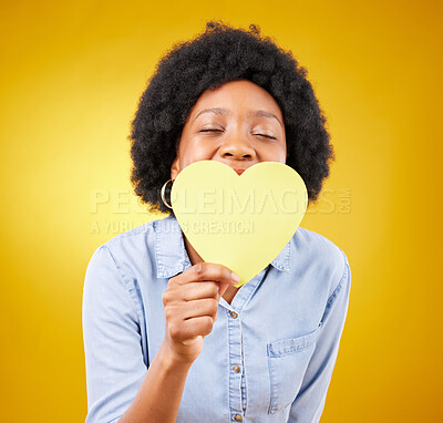 Buy stock photo Paper, heart and happy with black woman in studio for romance, positive and emotion. Happiness, love shape and giving with female isolated on yellow background for date, feelings and affectionate