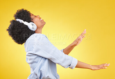 Buy stock photo Black woman, dance with headphones and freedom, music and happiness on yellow studio background. Happy female, carefree and dancing along to radio, audio streaming with fun and energy with technology