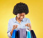Bag, wow and happy black woman shopping, excited and smile for sale in studio on yellow background. Discount, shopper and girl customer cheerful after boutique, retail or store deal posing isolated