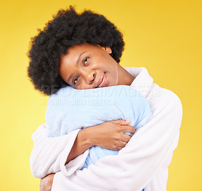 Buy stock photo Sleepy, tired and a black woman hugging a pillow on a yellow background in studio at bed time. Relax, wake up and comfort with an attractive young female holding a cushion in the morning after rest