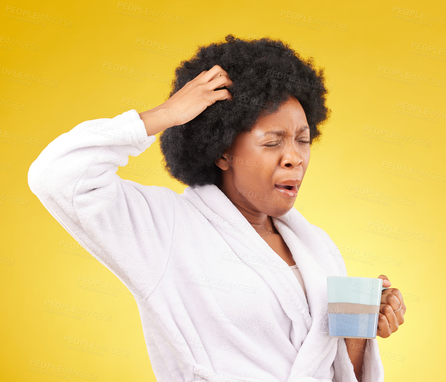 Buy stock photo Coffee, yawning and tired black woman in studio, waking up in the morning or sleepy isolated on a yellow background. Exhausted, insomnia and female scratching head with tea or caffeine in bathrobe.