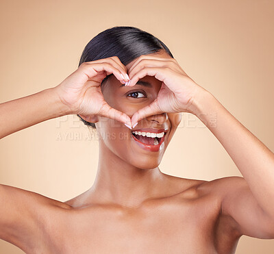 Buy stock photo Portrait, heart and hand gesture with a woman in studio on a beige background for beauty or skincare. Face, hands and emoji with an attractive young female posing for cosmetics or luxury wellness