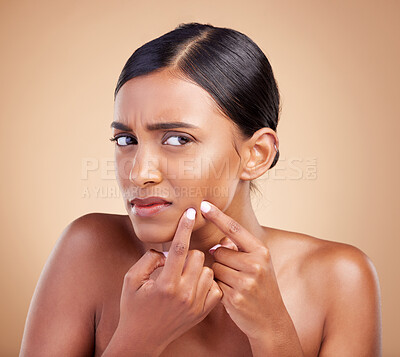 Buy stock photo Indian woman, pimple and skincare in studio for treatment, cosmetics and worried by background. Model girl, young asian and upset face for self care with cosmetic wellness, skin acne and aesthetic