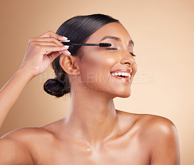 Buy stock photo Makeup, happy and woman with mascara for eyelashes isolated on a studio background. Smile, cosmetology and Indian girl with a brush for applying cosmetics, pomade product or treatment to lashes