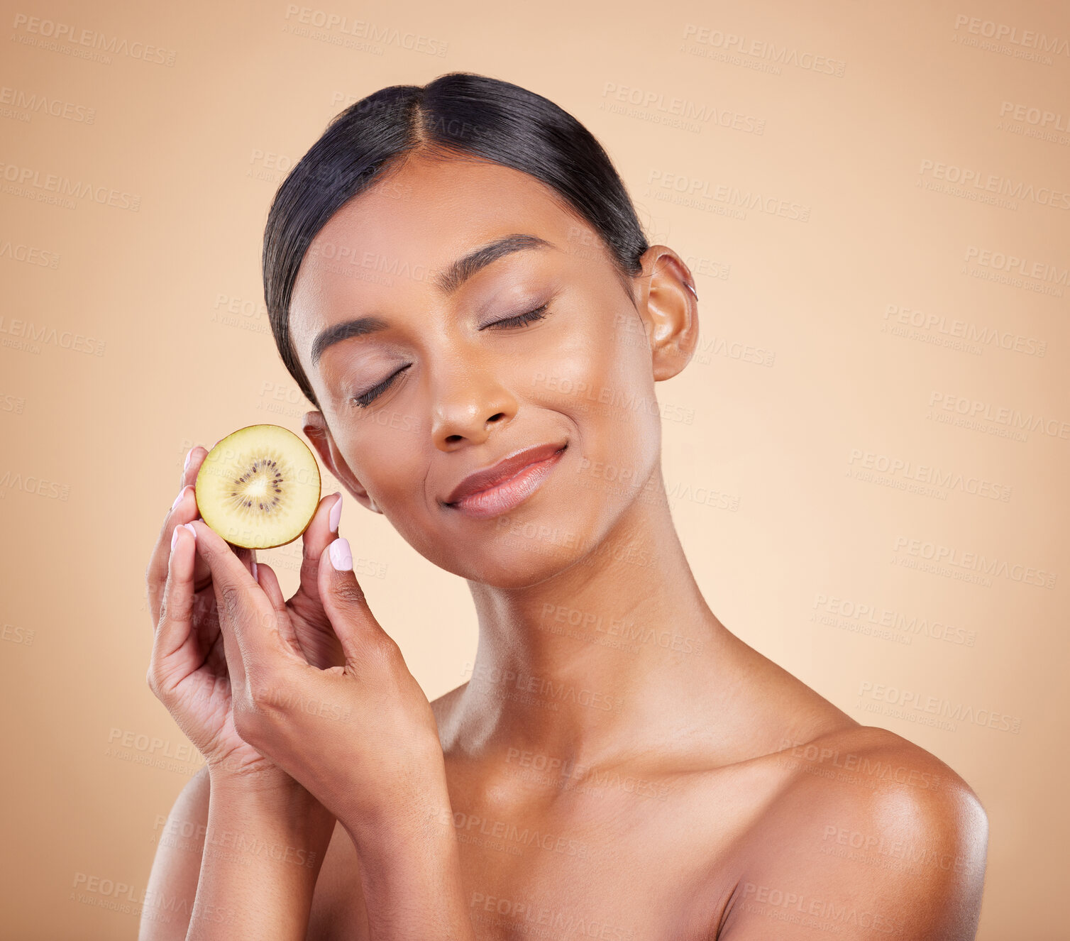 Buy stock photo Woman, kiwi and natural skincare, beauty and nutrition cosmetics against a studio background. Calm and happy female model holding fruit with smile for healthy organic facial, diet or spa treatment