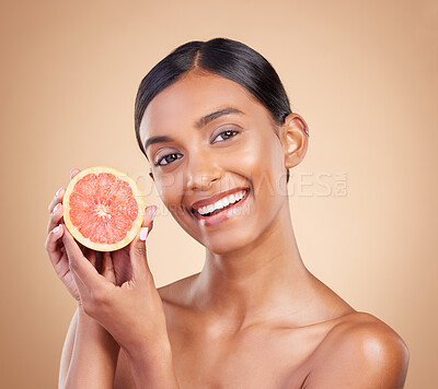 Buy stock photo Portrait, skincare and grapefruit with a model woman in studio on a beige background to promote beauty. Face, fruit and natural with an attractive young female posing for organic or luxury cosmetics