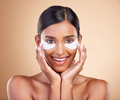 Buy stock photo Beauty, eye patch and portrait of a woman in studio for skincare, dermatology and cosmetics. Happy Indian female model with smile and collagen mask for self care moisture facial on brown background