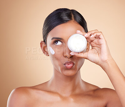 Buy stock photo Face, skincare or Indian woman with cream for beauty or wellness isolated on studio background. Cosmetics or girl model with facial self care or dermatology product for anti aging or dark circles